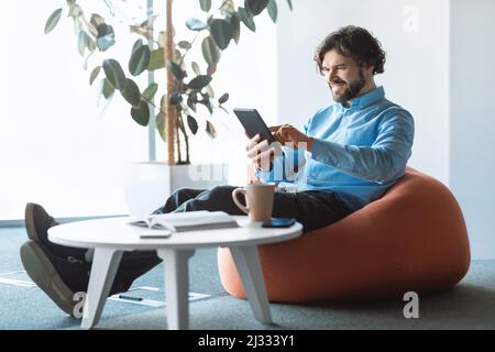 Portrait of smiling man using digital tablet at office Stock Photo
