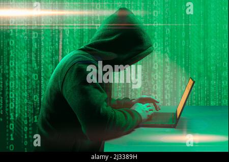 Faceless hacker at work with ROOTKIT VIRUS inscription, Computer