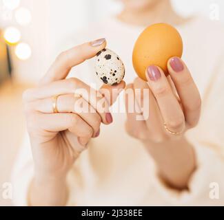 Woman holds chicken and quail eggs in her hands. Protein in food, concept of healthy food, vitamins and nutrients Stock Photo