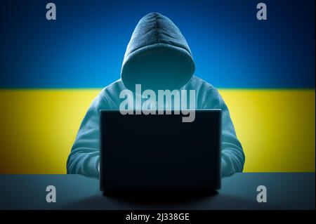 Faceless hooded anonymous computer hacker on Ukrainian flag background. Internet crime and electronic banking security. Hacker Attack, Virus Infected Stock Photo