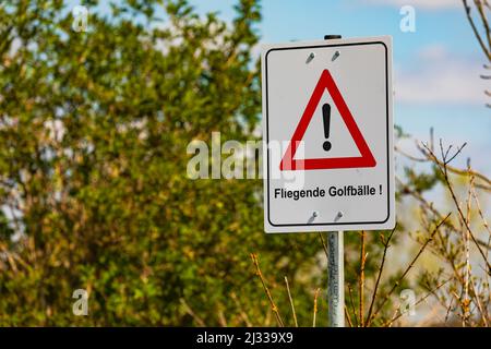 Caution flying golf balls as a warning sign on a golf course in Germany Stock Photo