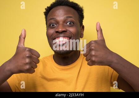 Portrait of happy african american handsome man laughing and showing thumb up gesture Stock Photo
