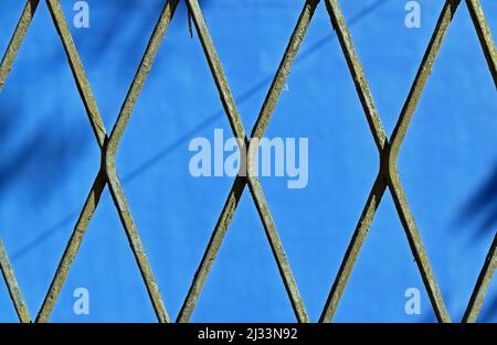 Green mesh, rhombus grid on blue background Stock Photo