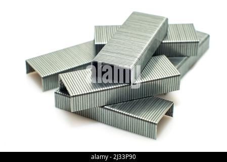 Staples from a stapler on a white background. Isolate of a bunch of staples scattered on the surface Stock Photo