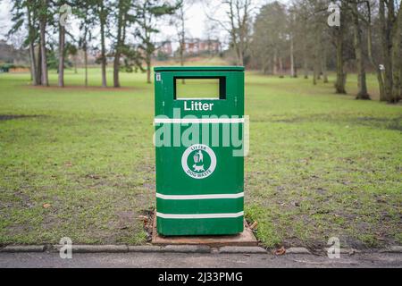 Close up of a green dog waste litter bin isolated in a UK country park. Stock Photo