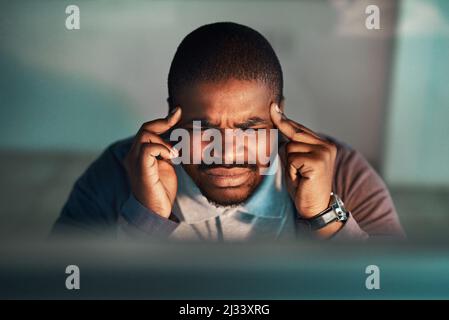 The long hours has gotten to him. Shot of a young businessman working late at the office. Stock Photo