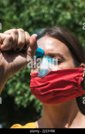 using hand held ventilator to cool down a virus protective face mask Stock Photo
