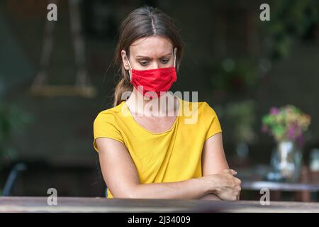young woman wearing a face mask feeling depressed during coronavirus epidemic Stock Photo