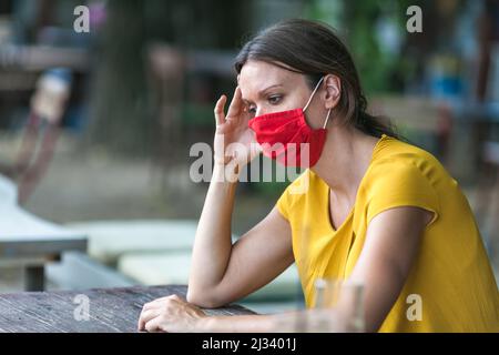 young woman wearing a face mask feeling sad during coronavirus epidemic Stock Photo