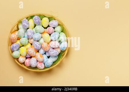 Easter basket of eggs on a yellow background with space for text. Top view copy space Stock Photo