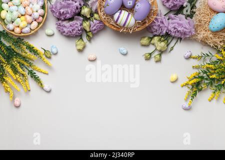 Easter concept. Flowers and blooming yellow sprigs of eggs in a basket on a gray background. Stock Photo