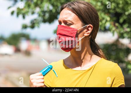 using hand held ventilator to cool down a virus protective face mask Stock Photo