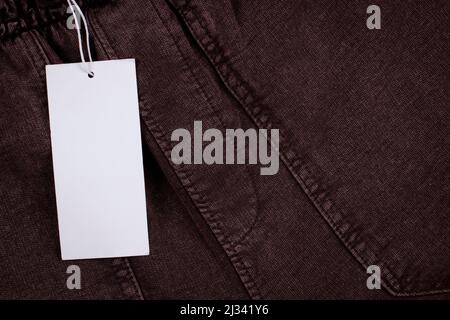 Blank black rectangular label tag on striped clothes background. Price tag tabel mock up with copy space Stock Photo