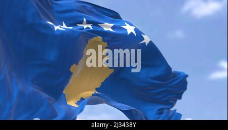 Detail of the national flag of Kosovo waving in the wind on a clear day. Kosovo is a partially recognized state in Southeast Europe. Selective focus. Stock Photo