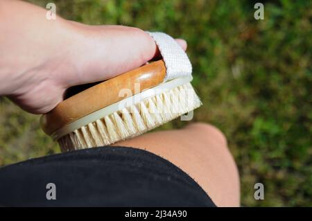 Close up on a person using the body brush on the leg Stock Photo