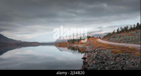 Road in the landscape with mountains and lake in Stora Sjöfallet National Park in autumn in Lapland in Sweden Stock Photo