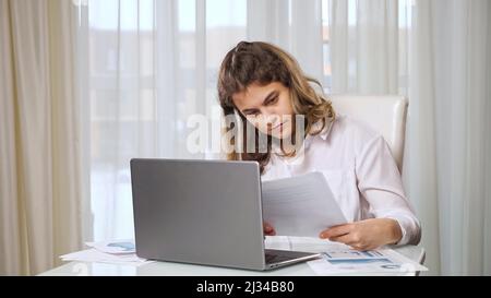 Disabled woman freelancer works on laptop from home at table Stock Photo