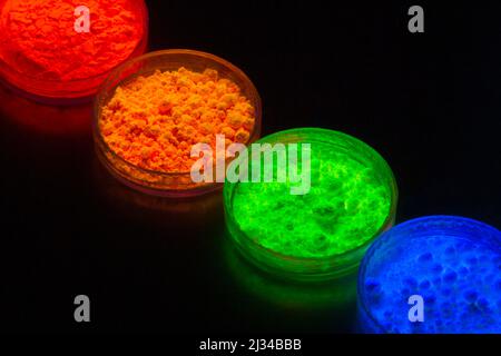 top view of colorful traditional holi powder in bowls isolated on dark background . happy holi.Concept Indian color festival called Holi Stock Photo