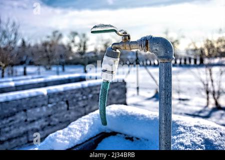 A closeup shot of Frozen water tap in the garden on sunny day Stock Photo