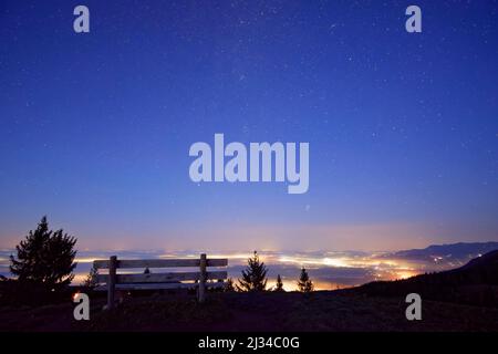 Observation bench on the Schwarzenberg with a view of the starry sky and illuminated places in the Rosenheimer Land, Schwarzenberg, Mangfall Mountains, Bavarian Alps, Upper Bavaria, Bavaria, Germany Stock Photo