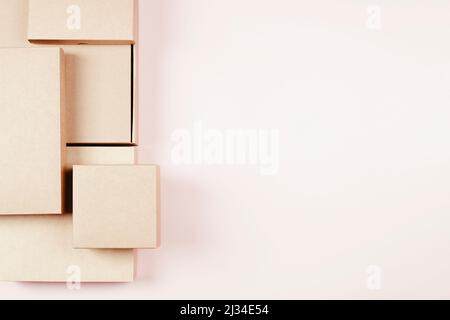 Group of brown cardboard boxes different size on pastel pink background. Mock up. Top view Stock Photo