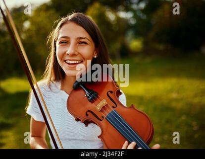 Practicing in nature really inspires her even more. Cropped shot of a young girl playing a violin outdoors. Stock Photo