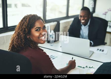 We make an awesome team. High angle portrait of a young businesswoman working across from a male colleague in the office. Stock Photo