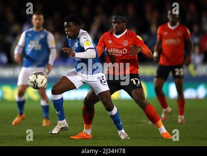 Peterborough United's Kwame Poku (centre left) and Luton Town's Pelly Ruddock Mpanzu (centre right) battle for the ball during the Sky Bet Championship match at the Weston Homes Stadium, Peterborough. Picture date: Tuesday April 5, 2022. Stock Photo