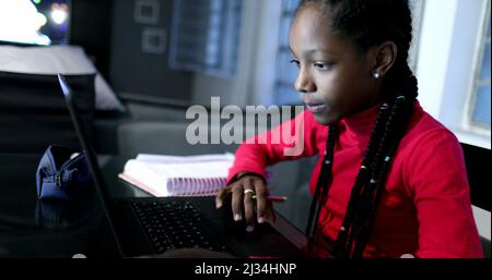 Candid black girl studying at night in front of laptop computer Stock Photo