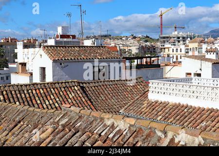 View over the roof tops taken from the sun terrace of a house in Estepona in Spain. Much building work is going on in the distance.