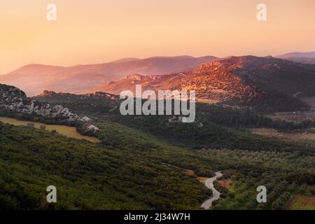 Pink sunset in turkey mountains with olive trees gardens at golden hour Stock Photo