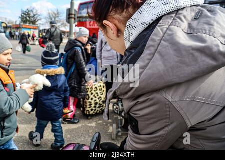Przemysl, Poland. 5th Apr, 2022. Refugees waiting to get on the bus for the train station and then to their new homes in Poland and abroad. Tesco in Przemysl is a former grocery-store turned Humanitarian aid Center where many Ukrainian refugees go as soon as they cross over the border into Poland. Dozens of aid organizations are set up and providing shelter, logistical support, SIM cards, internet food and health: everything to quickly care for and relocate refugees, all at no expense to them. Hundreds of volunteers show up from all over the world eager to assist and offer their skills, with Stock Photo