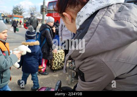 Przemysl, Poland. 4th Apr, 2022. Refugees waiting to get on the bus for the train station and then to their new homes in Poland and abroad. Tesco in Przemysl is a former grocery-store turned Humanitarian aid Center where many Ukrainian refugees go as soon as they cross over the border into Poland. Dozens of aid organizations are set up and providing shelter, logistical support, SIM cards, internet food and health: everything to quickly care for and relocate refugees, all at no expense to them. Hundreds of volunteers show up from all over the world eager to assist and offer their skills, with Stock Photo