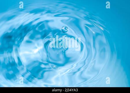water drop splash blue colored. Round water drop. Water drop in glass. Drops, splashes, spray, abstract shapes out of the water Stock Photo