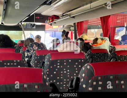Przemysl, Poland. 4th Apr, 2022. Refugees on the bus between Tesco and Train station in Przsemysl;.Tesco in Przemysl is a former grocery-store turned Humanitarian aid Center where many Ukrainian refugees go as soon as they cross over the border into Poland. Dozens of aid organizations are set up and providing shelter, logistical support, SIM cards, internet food and health: everything to quickly care for and relocate refugees, all at no expense to them. Hundreds of volunteers show up from all over the world eager to assist and offer their skills, without pay and great uncertainty of their own Stock Photo