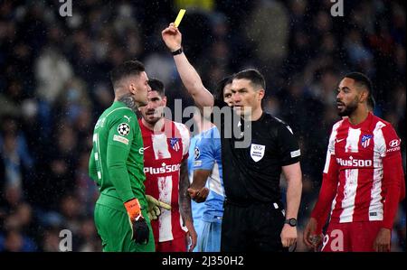 Referee Istvan Kovacs shows Manchester City goalkeeper Ederson a yellow card during the UEFA Champions League Quarter Final first leg match at the Etihad Stadium, Manchester. Picture date: Tuesday April 5, 2022. Stock Photo