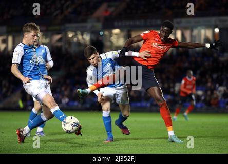 Peterborough United's Ronnie Edwards (centre) and Luton Town's Elijah Adebayo (right) battle for the ball during the Sky Bet Championship match at the Weston Homes Stadium, Peterborough. Picture date: Tuesday April 5, 2022. Stock Photo