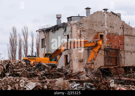 Excavator on demolition site. Process of demolition of old industrial building Stock Photo