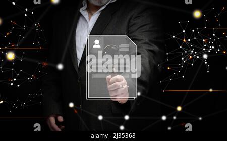 a businessman in a suit stands with a magnifying glass and examines the candidate's resume for the position. Search for talented employees, career gro Stock Photo