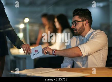 Office romance. Cropped shot of a love note being passed from one colleague to another. Stock Photo