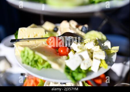 Hamburg, Germany. 05th Mar, 2022. A plate of various cheeses, blueberries and tomatoes stands on a richly set breakfast table in the sunshine. Credit: Jonas Walzberg/dpa/Ģ����ý Live News Stock Photo