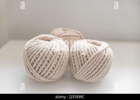 bobbins of light beige pastel color for weaving macrame needlework on a light background Stock Photo