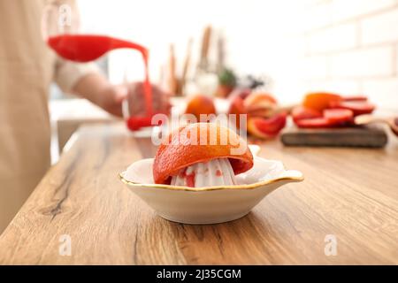 Ceramic juicer with orange on wooden table Stock Photo
