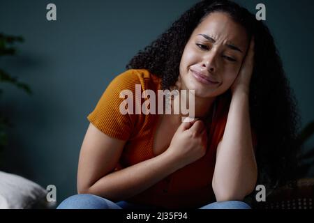 Cry a river if you must, just dont drown in it. Shot of a young woman feeling unhappy at home. Stock Photo