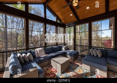 Cozy screened porch in springtime, full of blooms trees in the background. Stock Photo