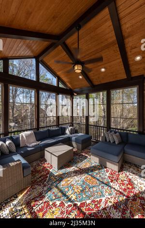 Cozy screened porch in springtime, full of blooms trees in the background. Stock Photo