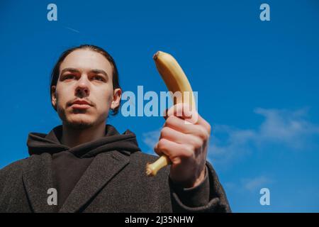 killer man with a banana instead of a gun. angry and confident look Stock Photo