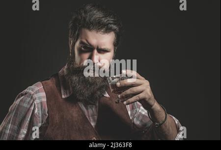 Bartender leather apron holding whisky cocktail in glass. Old traditional whiskey drink - gentlemen beverage. Stock Photo