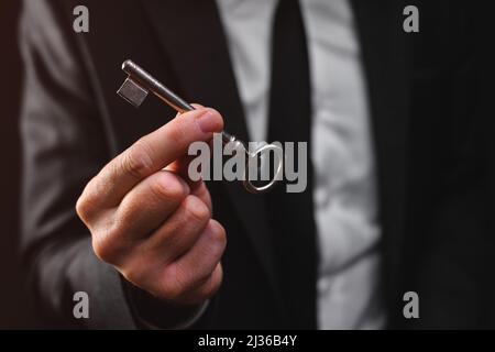 Businessman holding vintage door key, selective focus Stock Photo