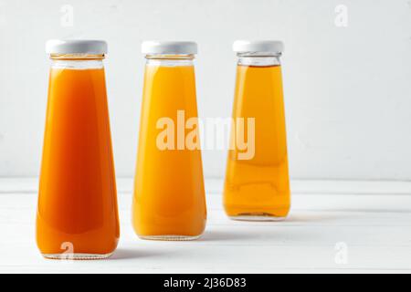 Glass bottles of different juices on white background Stock Photo